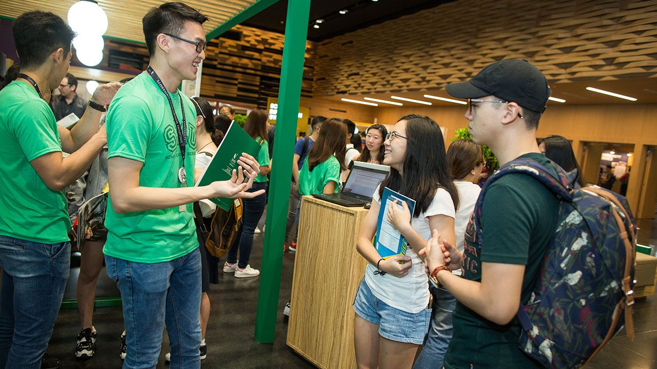 Students talking to prospective students at the Open House information booth